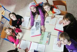 Lycklig barn med lärare i skola klassrum foto