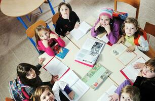 Lycklig barn med lärare i skola klassrum foto