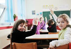 Lycklig barn med lärare i skola klassrum foto