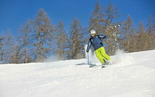 skidåkning på nysnö på vintersäsongen på vacker solig dag foto