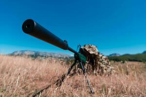 armén soldat innehav prickskytt gevär med omfattning och siktar i skog. krig, armé, teknologi och människor begrepp foto