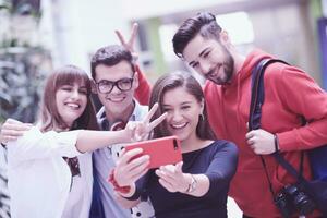 grupp av multietnisk tonåringar tar en selfie i skola foto