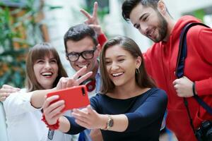 grupp av multietnisk tonåringar tar en selfie i skola foto