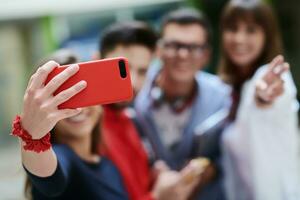 grupp av multietnisk tonåringar tar en selfie i skola foto