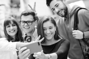 grupp av multietnisk tonåringar tar en selfie i skola foto