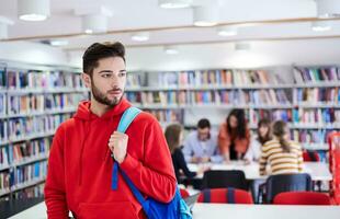 de studerande användningar en bärbar dator och en skola bibliotek foto