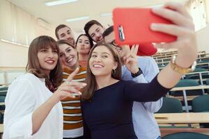 grupp av multietnisk tonåringar tar en selfie i skola foto