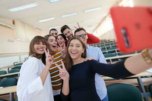 grupp av multietnisk tonåringar tar en selfie i skola foto