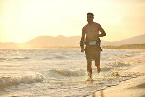 porträtt av en ung kitsurf man på strand på solnedgång foto
