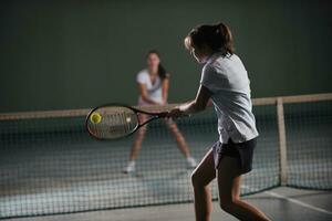 ung flickor spelar tennis spel inomhus- foto