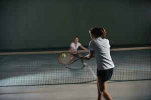 ung flickor spelar tennis spel inomhus- foto