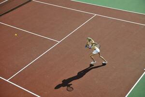 ung kvinna spela tennis utomhus foto