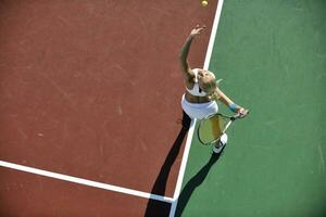 ung kvinna spela tennis utomhus foto