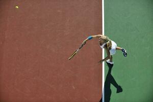 ung kvinna spela tennis utomhus foto