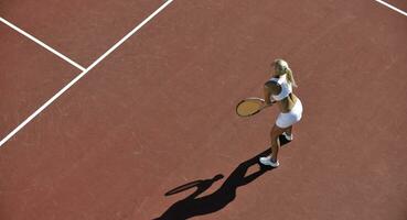 ung kvinna spela tennis utomhus foto