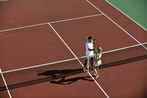 Lycklig ung par spela tennis spel utomhus- foto