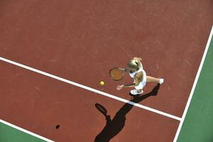 ung kvinna spela tennis utomhus foto