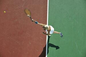 ung kvinna spela tennis utomhus foto