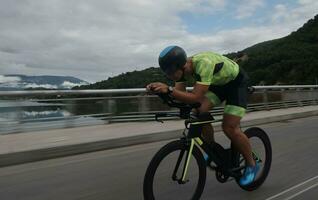 triathlonatlet som cyklar på morgonträning foto