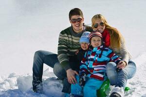 familj har roligt på färsk snö på vinter- semester foto