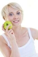 Lycklig ung kvinna äta grön äpple isolerat på vit foto