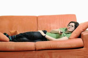 Lycklig kvinna koppla av på orange soffa foto