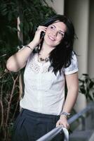 ung glad affärskvinna talar med mobiltelefon foto