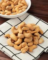 ovanifrån av cashewnötter i vit skål på bordet, platt låg foto