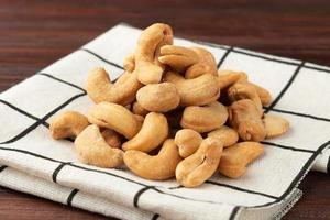 cashewnötter på bordet, plattläggning, hälsosamt mellanmål, vegetarisk mat foto