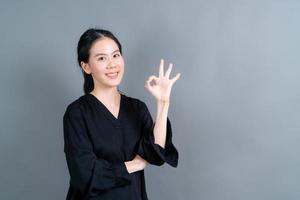 ung asiatisk kvinna som ler och visar ok tecken foto