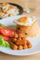 stekt ris med korv och stekt ägg på bordet foto
