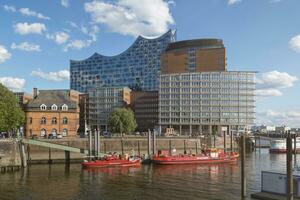 hamburg, Tyskland - 29 Maj 2019 hamburg hamn brand kämpe båtar och elbphilharmonie konsert hall i de bakgrund foto