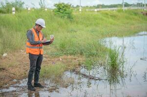 miljöingenjörer inspekterar vattenkvaliteten, ta med vatten till labbet för testning, kontrollera mineralinnehållet i vatten och jord, kontrollera föroreningar i vattenkällor. foto