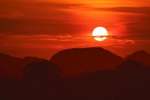 solnedgång på natten röd himmel tillbaka över siluett träd berg foto