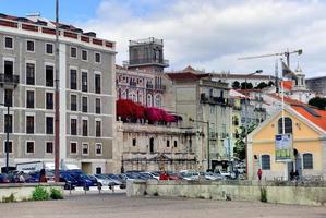 Lissabon, Portugal - 26 april 2019, färgglad bougainvillea -trädgård bland byggnaderna foto