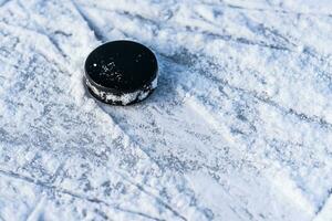 svart hockey puck lögner på is på stadion foto