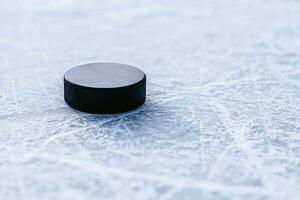 svart hockey puck lögner på is på stadion foto