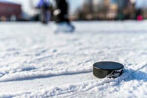 svart hockey puck lögner på is på stadion foto