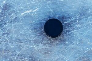 svart hockey puck lögner på is på stadion foto