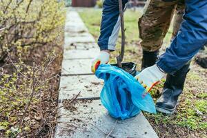 en man växter en ung frukt träd. de jordbrukare packar upp en ny fröplanta och sätter den i de jord. de begrepp av miljö- skydd och ekologi foto