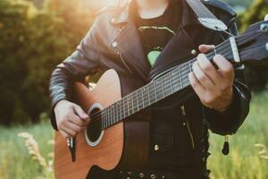 musiker man spelar gitarr på solnedgång närbild foto