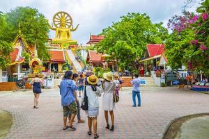människor vid den gyllene buddhastatyn vid wat phra yai -templet, koh samui, thailand, 2018 foto