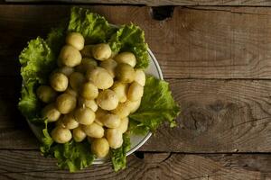 en tallrik av kokt ny färsk potatisar på trä- bakgrund. fri Plats foto