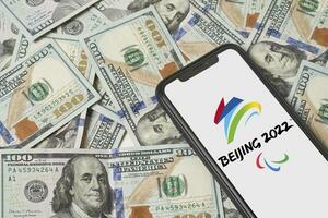 beijing 2022 vinter- paralympics symol på telefon skärm över oss dollar foto