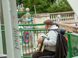 Wien, österrike - 2023-05-13 en gata musiker spelar de knapp dragspel. foto