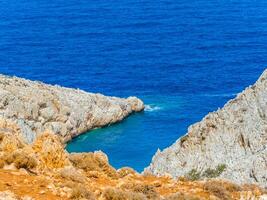 orange och vit klippor och djup blå hav foto