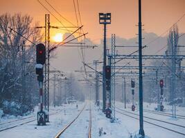 tömma järnväg vägar nära tåg station på en snö täckt kväll foto