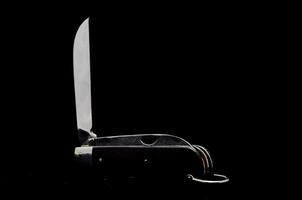 en kniv med en svart bakgrund foto