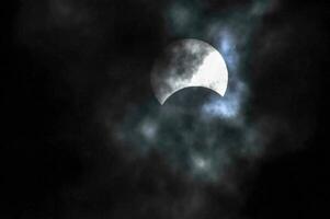 de måne är sett i de mörk himmel med moln foto