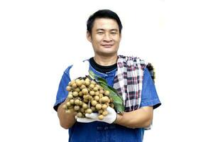 asiatisk man jordbrukare innehar longan frukter, isolerat på vit bakgrund. begrepp, lantbruk ockupation. thai jordbrukare växa organisk longan som ett exportera produkt av thailand. foto